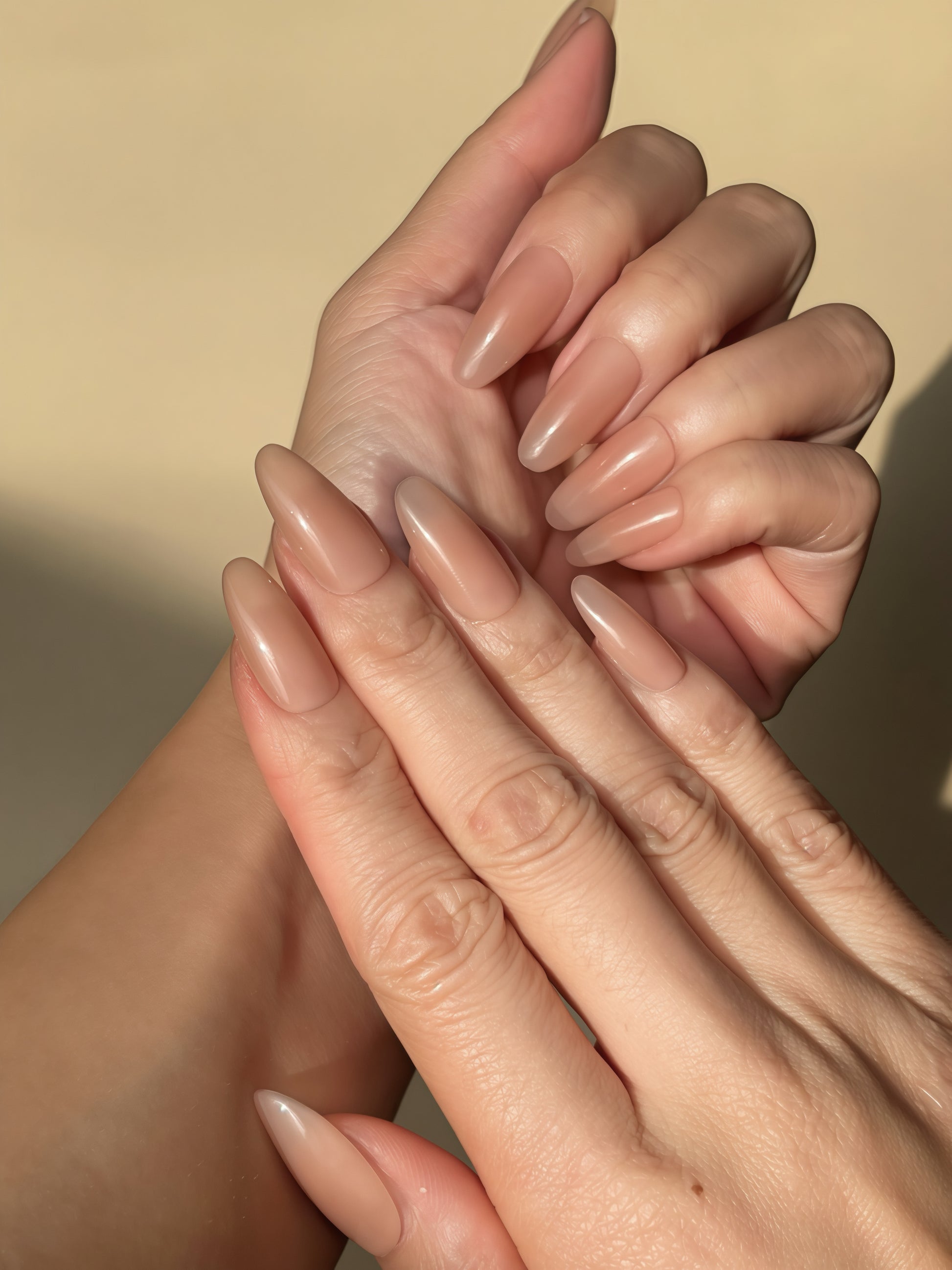 Bare Eternity nude oval press-on nails shown on both hands in natural sunlight
