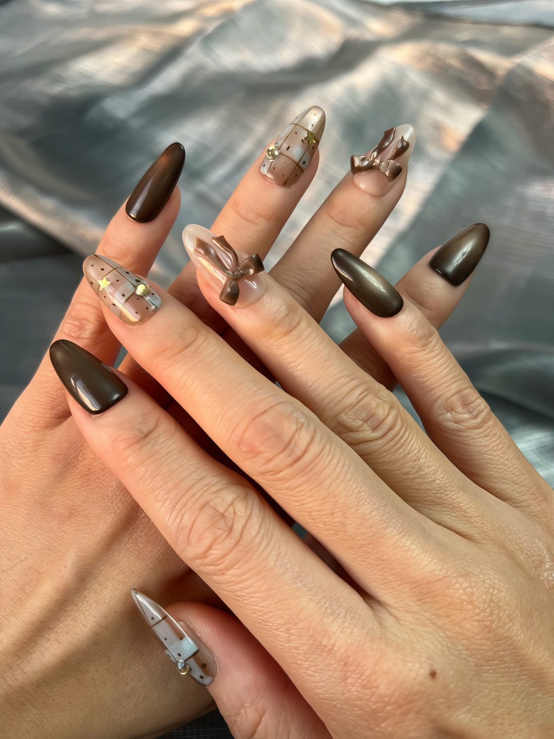 Cocoa Giftbox brown Christmas press-on nails with cat-eye gradient, 3D bow design, and festive giftbox pattern — elegant winter manicure UK