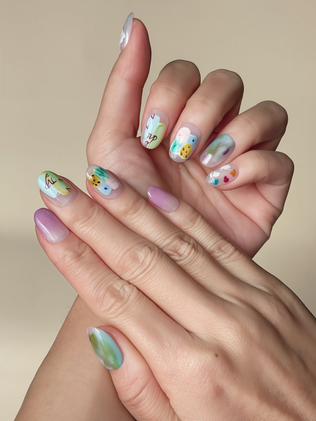 Dreamy Grove press-on nails flatlay showing lilac, blue, green watercolor patterns