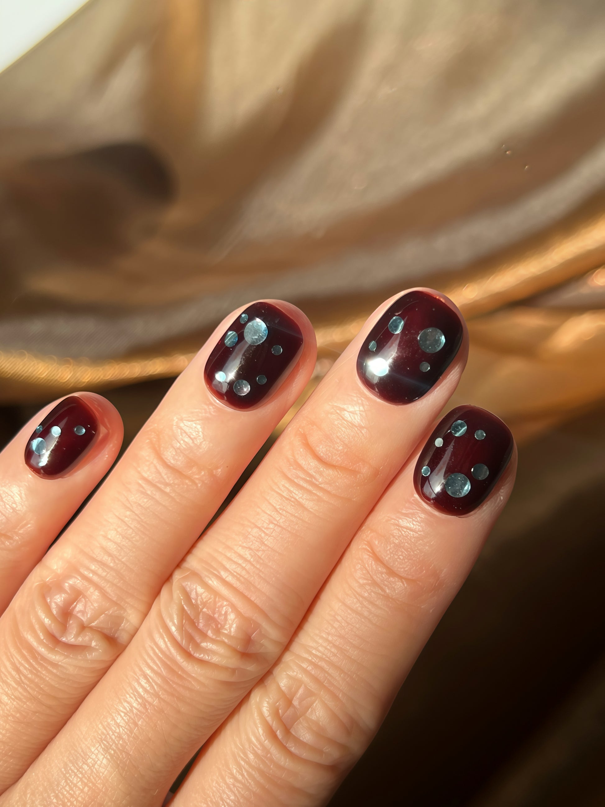 Close-up of Espresso Dots press-on nails with deep espresso-brown base and soft blueberry-toned dots