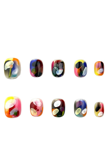 Dopamine Crush press-on nails flatlay showing colorful abstract designs with orange, lilac, yellow, and blue brushstroke patterns by Momento.