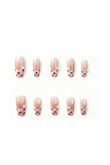 Gentle Wild press-on nails flatlay featuring blush-pink French tips with deep red leopard spots and tiny pearl details.