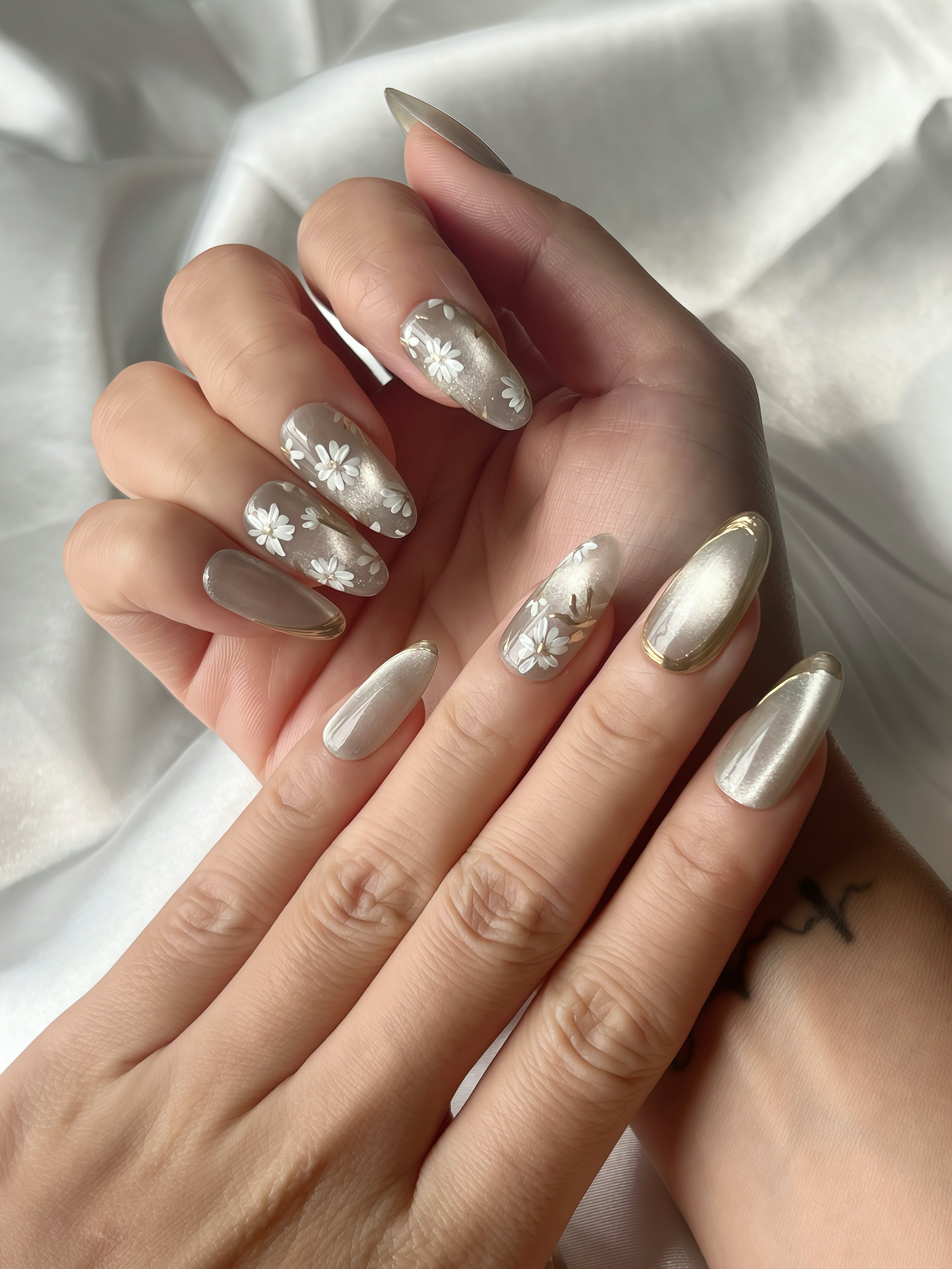 Close-up of Jade Whisper floral jade grey press-on nails styled on hand under soft satin light