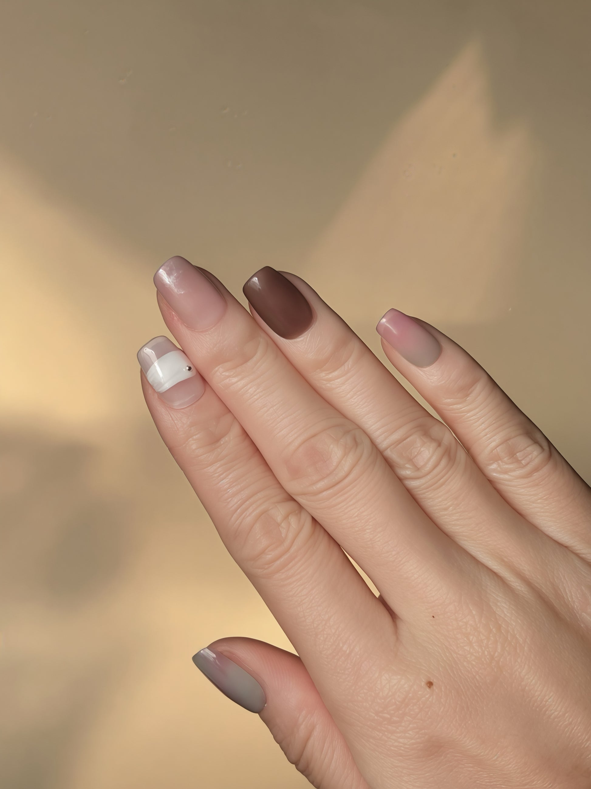 Close-up of Peony Mist press-on nails featuring pink, brown, and teal watercolor blends on a square shape.