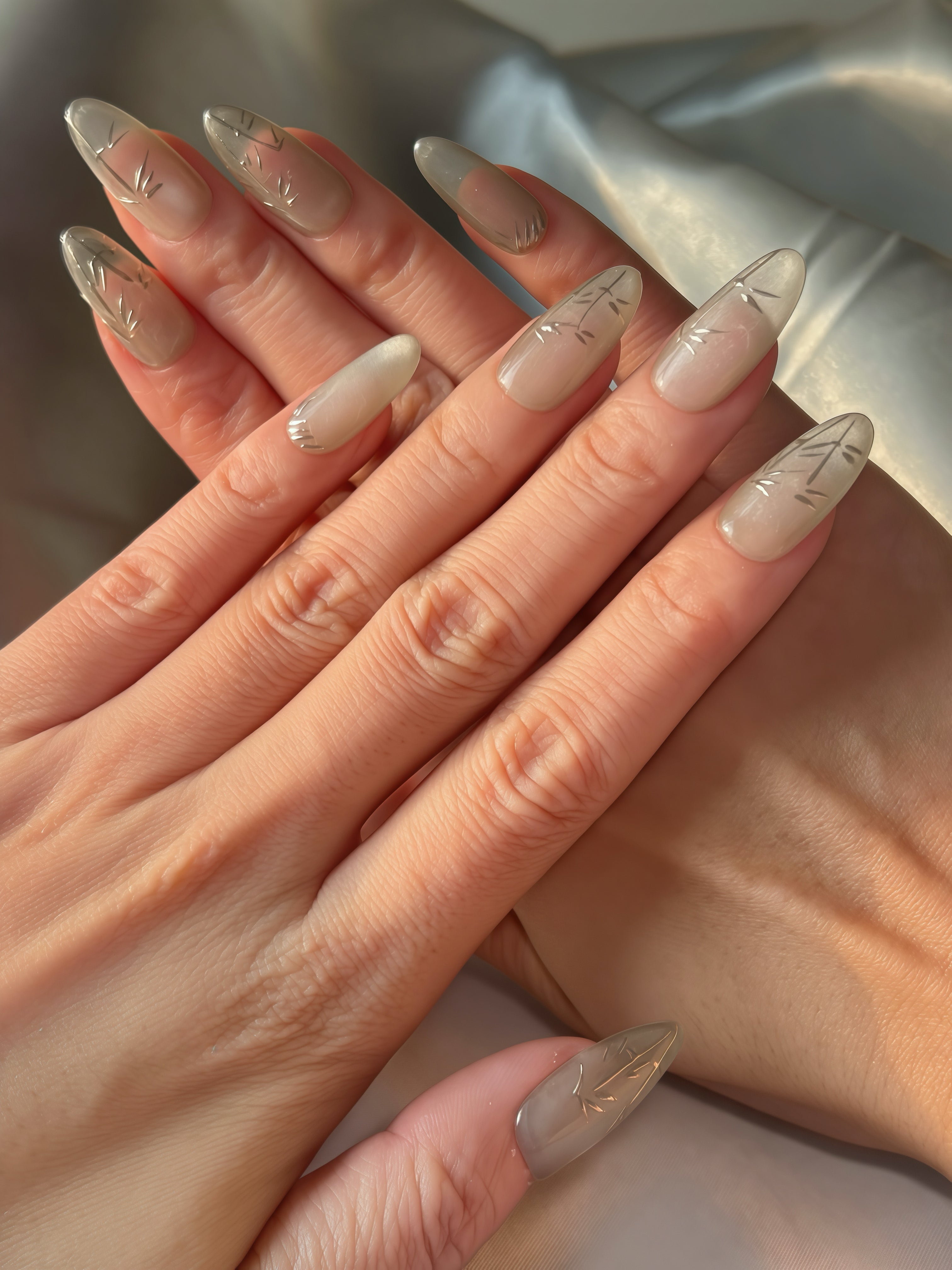 Shadow Bamboo grey-green oval press-on nails with gold bamboo strokes in natural sunlight — Momento